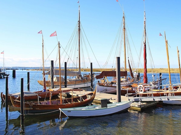 Boats dock at the tranquil marina, surrounded by calm water and a serene shoreline.