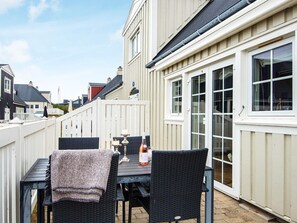 Eine Terrasse mit Tisch, Stühlen, einer Flasche und einer Kerze.
