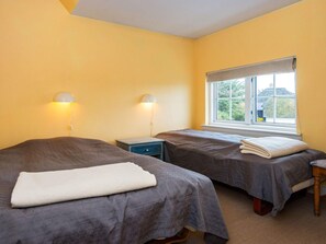 A room with two beds, a window with a view, and bedside lamps.