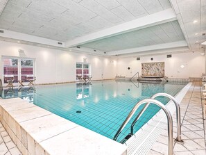 An indoor swimming pool with clear water, tiled walls, and a ceiling with recessed lighting. - 4 Star Holiday Home in Skagen (Skagen)