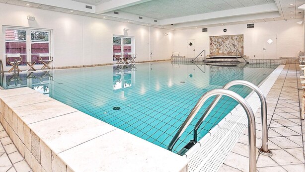 An indoor swimming pool with clear water, tiled walls, and a ceiling with recessed lighting. - 4 Star Holiday Home in Skagen (Skagen)