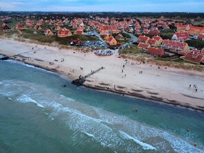 An aerial view of a coastal town with houses, a beach, and a pier. - 4 Star Holiday Home in Skagen (Skagen)