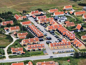 A residential area with multiple houses, a main road, and parked cars.