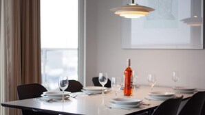 A dining area with a table set for four, including wine glasses, plates, and cutlery.