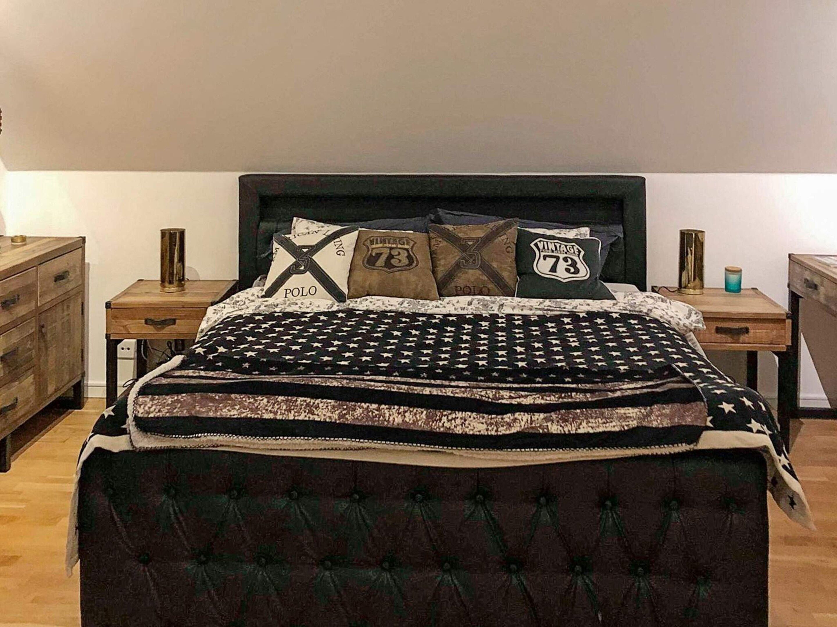 A bedroom with a bed, two nightstands, a dresser, and a lamp.