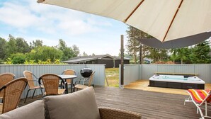 A wooden deck with outdoor furniture, a hot tub, and a barbecue grill. - 9 Person Holiday Home in Vaeggerlose (Vaeggerlose)