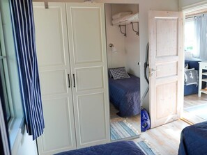 Ein Schlafzimmer mit einem Bett, einem Kleiderschrank, einem Staubsauger und einem Badezimmer mit Dusche.