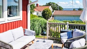 A deck with a sofa, chairs, and a small table. - 4 Star Holiday Home in Onsala (Gottskar)
