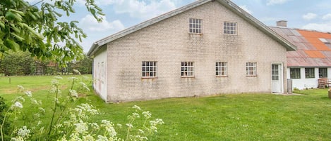 A large, single-story building with a brick exterior and a sloped roof.