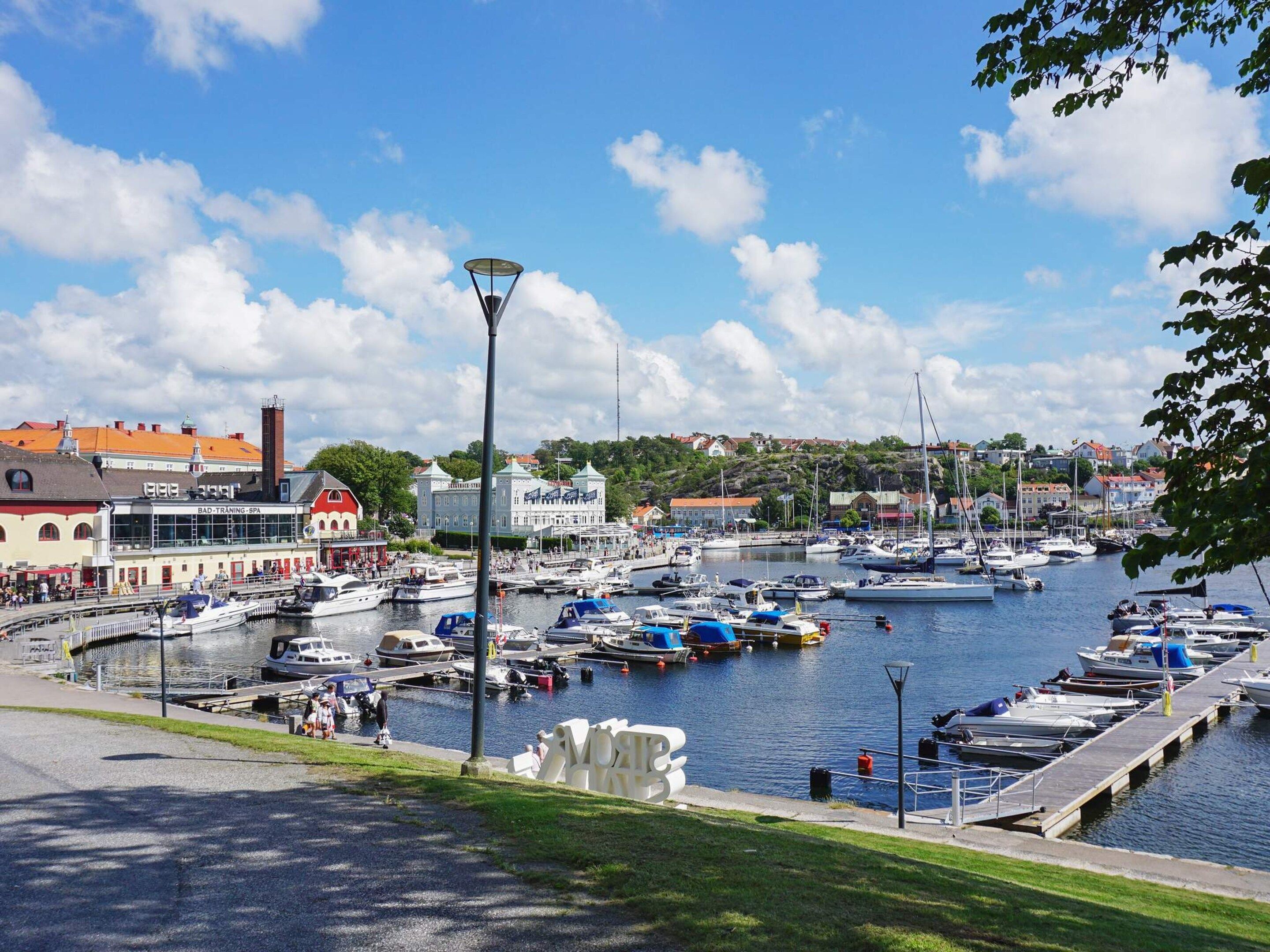 Ein Yachthafen mit vertäuten Booten, ein Gebäude mit der Aufschrift 'BAD-TRAINING-SPA' und einem klaren Himmel.