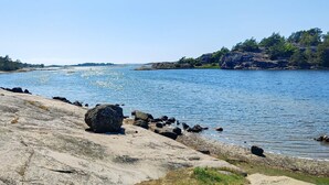 A rocky shoreline with calm water, clear skies, and distant land. - 4 Star Holiday Home in Stromstad (Stromstad)