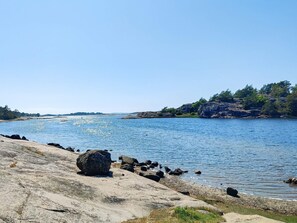 A rocky shoreline with calm water, clear skies, and distant land. - 4 Star Holiday Home in Stromstad (Stromstad)