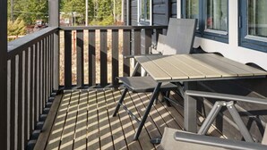 A wooden deck with a table and chairs, overlooking a forested area. - 6 Person Holiday Home in Kopparberg (Kopparberg)