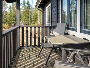 A wooden deck with a table and chairs, overlooking a forested area. - 6 Person Holiday Home in Kopparberg (Kopparberg)