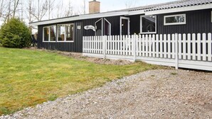 A black building with a white picket fence, a chimney, and a satellite dish. - 10 Person Holiday Home in Ronde (Ronde)