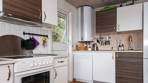 A modern kitchen with white cabinets, a stainless steel range hood, and a window providing natural light. - 10 Person Holiday Home in Ronde (Ronde)