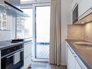 A modern kitchen with a built-in oven, a stovetop, and a sink.