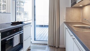 A modern kitchen with a built-in oven, a stovetop, and a sink.