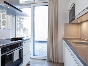 A modern kitchen with a built-in oven, a stovetop, and a sink.