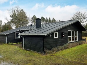 A black wooden cabin with a gabled roof, a chimney, and a number '9' on the side. - 6 Person Holiday Home in Blokhus (Blokhus)