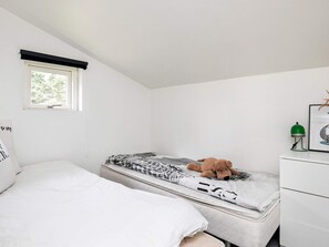A bedroom with a bed, a mattress, a bedside table with a lamp, and a window. - 6 Person Holiday Home in Blokhus (Blokhus)