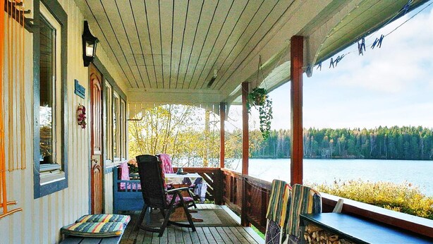 A covered porch with a view of a lake, wooden benches, and a table with chairs. - 2 Person Holiday Home in Bengtsfors-by Traum (Bengtsfors)