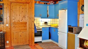 A compact kitchen with blue cabinets, a white refrigerator, a stove, and a microwave. - 2 Person Holiday Home in Bengtsfors-by Traum (Bengtsfors)