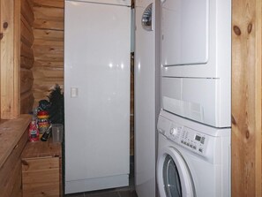 A compact laundry area with a washing machine and a white refrigerator. - 4 Star Holiday Home in Salen (Salen)