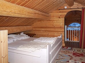 A wooden interior with a bed, a small table, and a window with bars. - 4 Star Holiday Home in Salen (Salen)