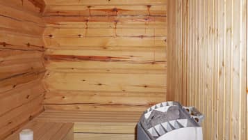 Un sauna de madera con un banco y un difusor de vapor.