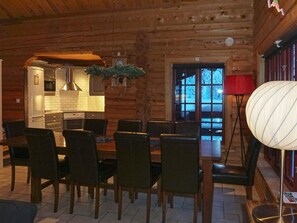A log cabin interior with a dining area, kitchen, and a large window. - 4 Star Holiday Home in Salen (Salen)