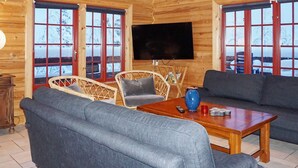 A log cabin interior with a sofa, chairs, a table, and a television. - 4 Star Holiday Home in Salen (Salen)