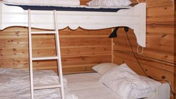 A bunk bed with a ladder, white bedding, and a wooden cabin interior.