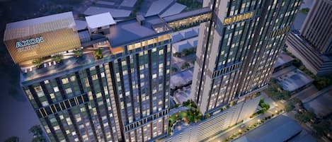 A high-rise hotel with multiple floors, large windows, and a rooftop area.
