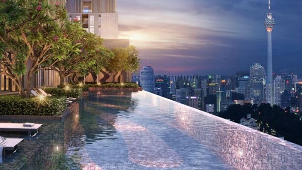 Piscina infinita en la azotea con sillones, rodeada de vegetación y vistas a la ciudad.