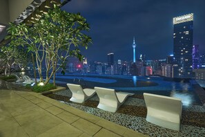 A rooftop pool area with lounge chairs and a city skyline view. - Sleeping Lion Suites (Kuala Lumpur)