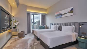 A hotel room with two beds, a TV, a painting, and a city view.
