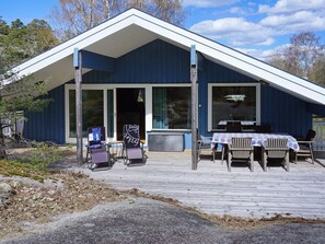 A building with a covered porch, outdoor seating, and a view of the surrounding landscape.