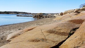 A rocky shoreline with a dock extending into calm water.