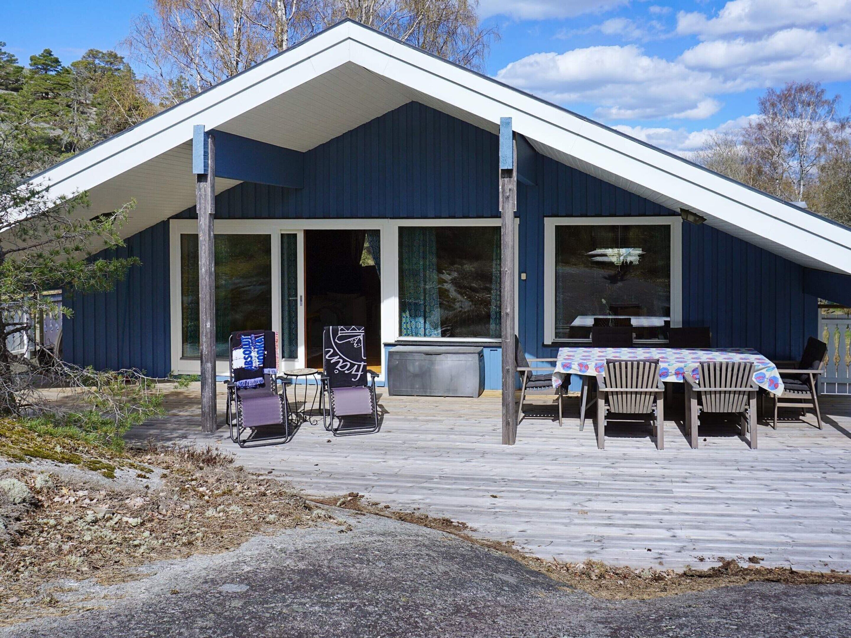 A building with a covered porch, outdoor seating, and a view of the surrounding landscape.