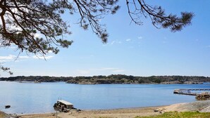 A lakeside view with a dock, a boat, and a path leading to the water.