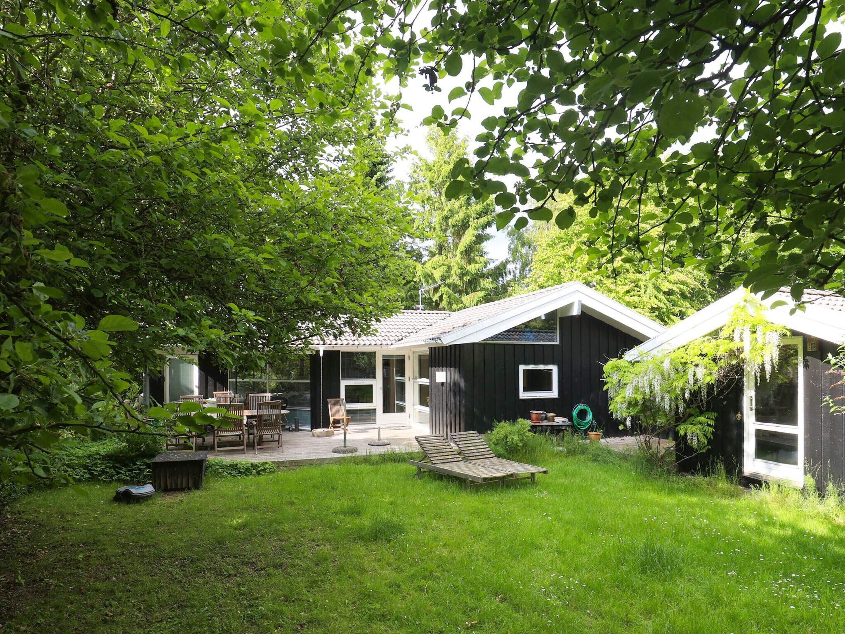 A house with a covered patio, a small deck, and a garden area.