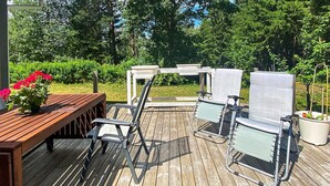 An outdoor deck with a wooden bench, metal chairs, and a potted plant. - 6 Person Holiday Home in Bottnaryd (Bottnaryd)
