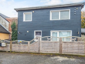 A two-story house with a dark exterior, white-framed windows, and a wooden gate. - 4 Person Holiday Home in Ansager (Ansager)