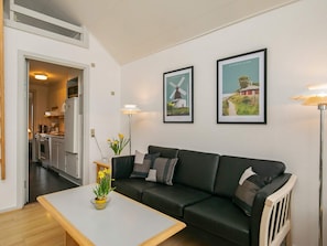 A modern living room with a sofa, coffee table, and two framed pictures on the wall. - 6 Person Holiday Home in Rudkobing (Rudkobing)