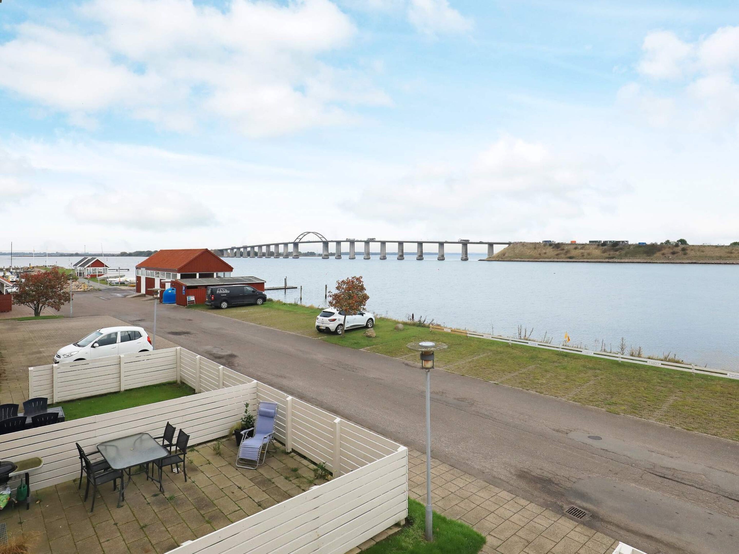 A waterfront property with a dining area, a covered outdoor seating, and a view of a bridge.