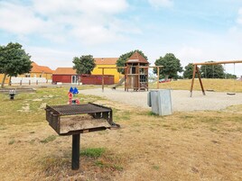 Un parque infantil con columpios, un tobogán y una estructura para escalar.