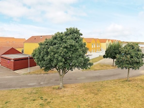 A row of colorful buildings with a paved road in front. - 6 Person Holiday Home in Rudkobing (Rudkobing)