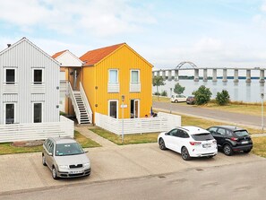 A residential area with a yellow house, a white house, and a bridge over a body of water. - 6 Person Holiday Home in Rudkobing (Rudkobing)