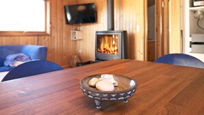 A wooden interior with a table, chairs, a television, and a fireplace. - 6 Person Holiday Home in Humble (Sydlangeland)